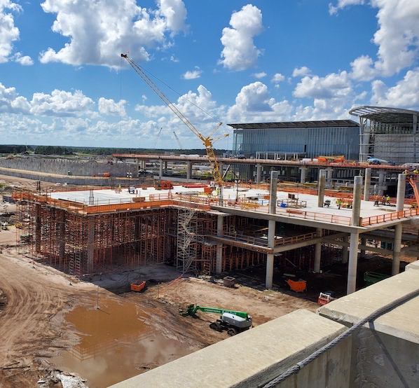 Multi-level concrete structure under construction with a tower crane